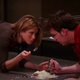 Screenshot of Rachel and Chandler from "Friends" eating cheesecake off of ground